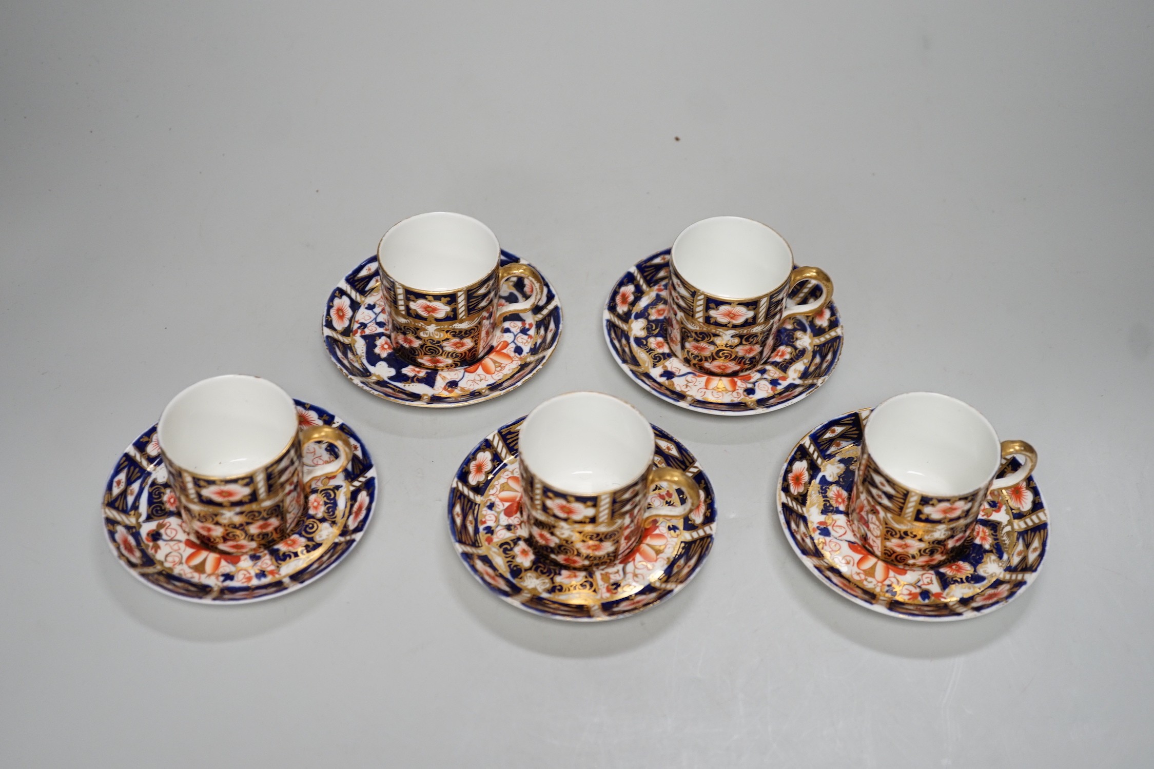Five Royal Crown Derby Imari coffee cans and saucers